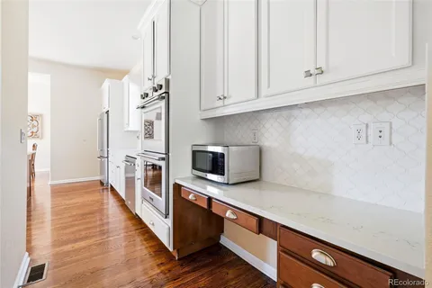 a kitchen with stainless steel appliances white cabinets and a refrigerator