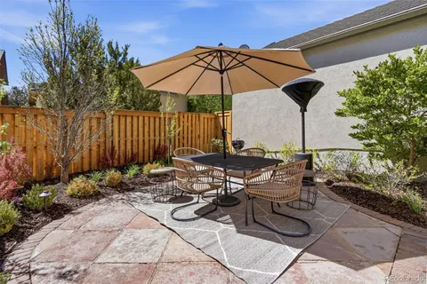 a view of a patio with couches table and chairs and potted plants