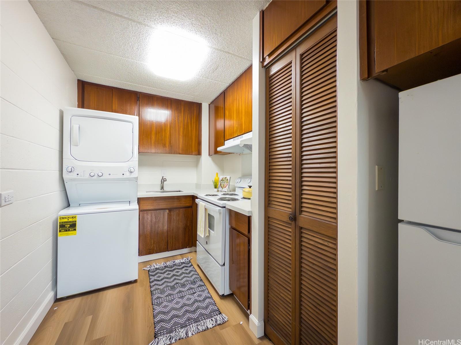 2015 Wilder Avenue, Unit 2E Honolulu, HI 96822 - Photo 2 of 12 a kitchen with a stove a sink and a refrigerator