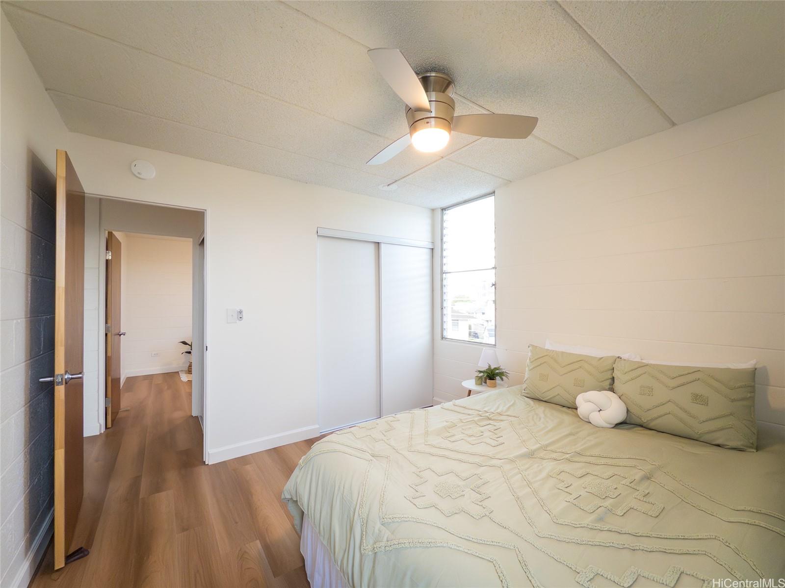 2015 Wilder Avenue, Unit 2E Honolulu, HI 96822 - Photo 6 of 12 a bedroom with a bed and a chandelier