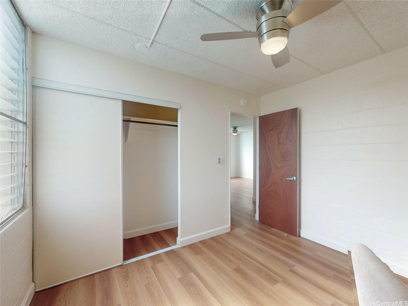 2015 Wilder Avenue, Unit 2E Honolulu, HI 96822 - Photo 9 of 12 an empty room with wooden floor and ceiling fan