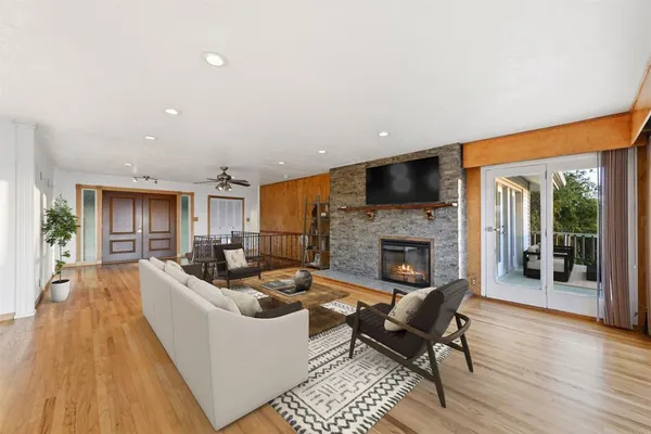 a view of empty room with wooden floor and fireplace