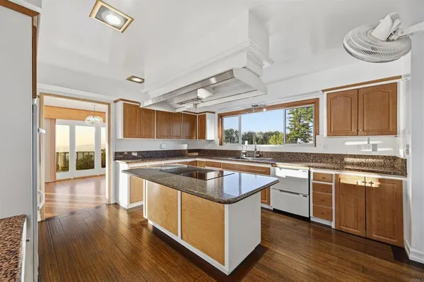 a kitchen with granite countertop a sink stove and refrigerator