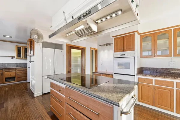 a kitchen with stainless steel appliances granite countertop a sink and a refrigerator
