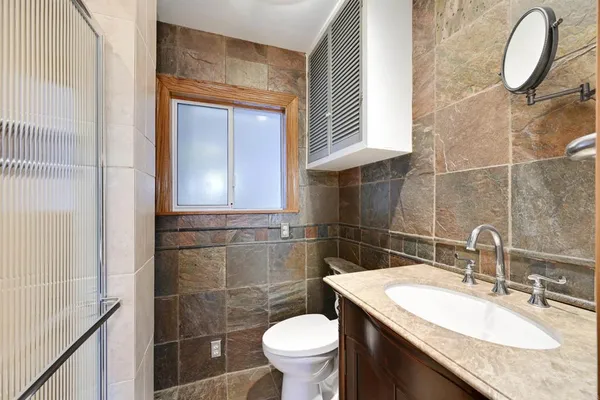 a spacious bedroom with a bed a couch and dresser