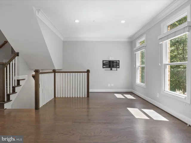 a large white kitchen with kitchen island a large counter top and stainless steel appliances
