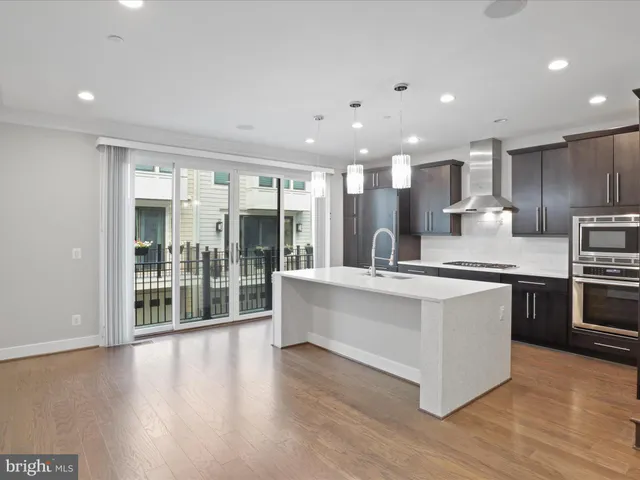 a kitchen with stainless steel appliances kitchen island granite countertop a stove a sink a refrigerator and a refrigerator