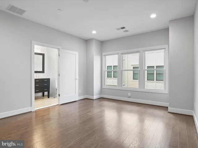 a bathroom with a granite countertop sink a large mirror and a window