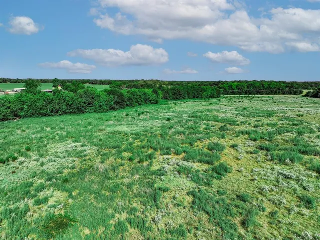 a view of a green field with a building in the back