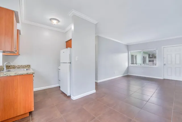 a view of a kitchen with furniture and refrigerator