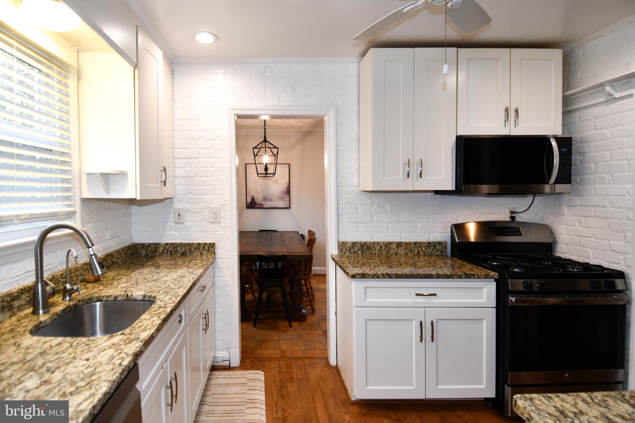 9325 Long Branch Parkway Silver Spring, MD 20901 - Photo 5 of 27 a kitchen with granite countertop a sink a stove and cabinets