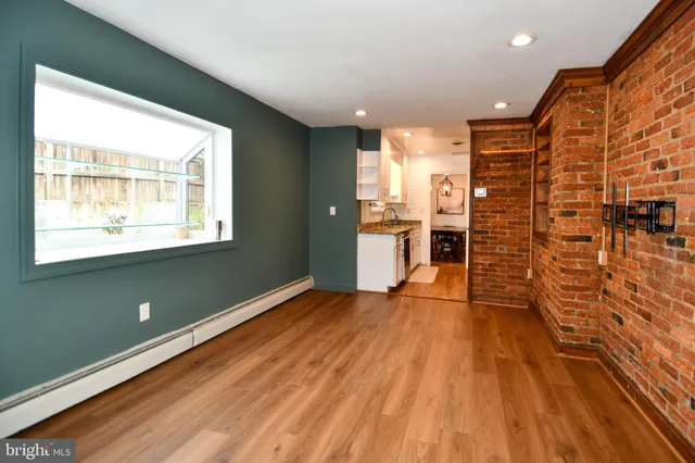 a view of empty room with wooden floor and windows