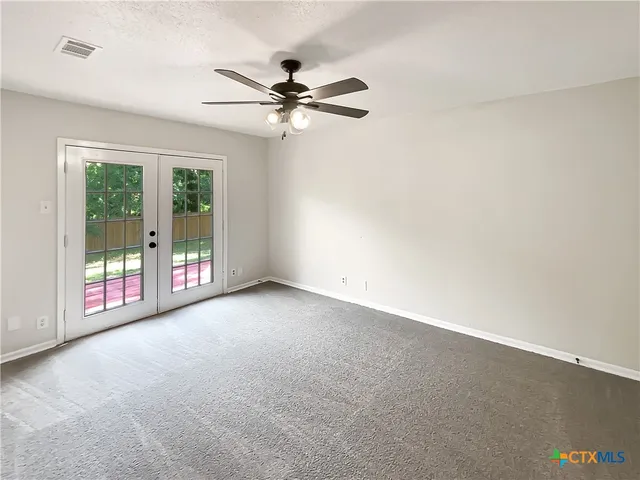 a view of a livingroom with a ceiling fan and window