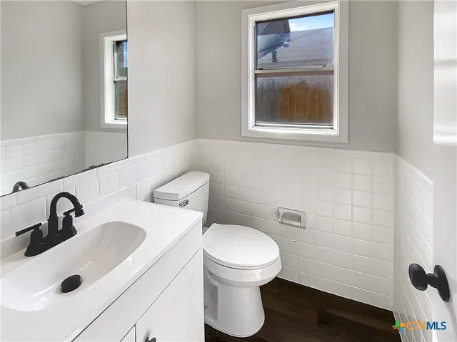 a bathroom with a toilet sink and mirror