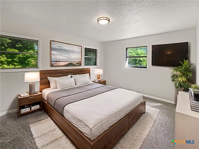 a bedroom with bed and a flat screen tv