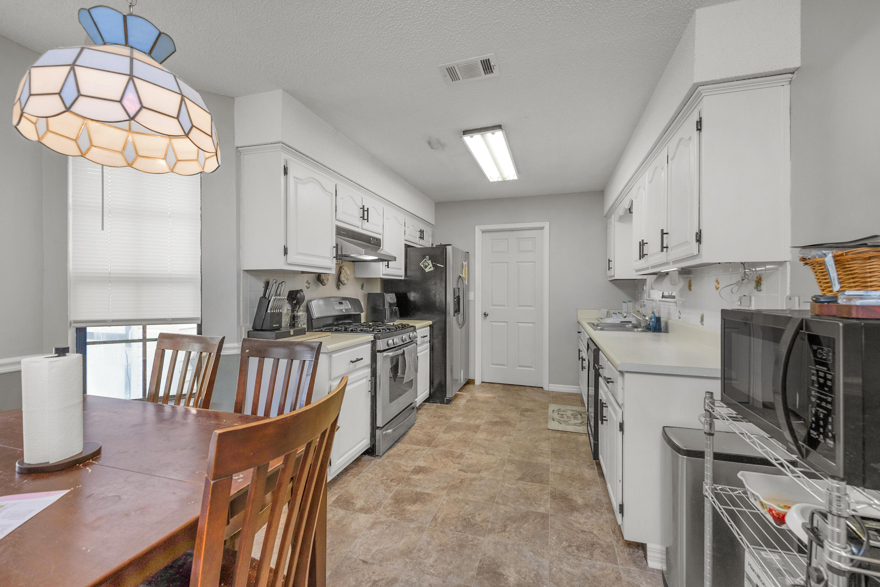 2788 Keats Drive Crestview, FL 32539 - Photo 12 of 32 a kitchen with granite countertop a stove a sink a refrigerator and a dining table