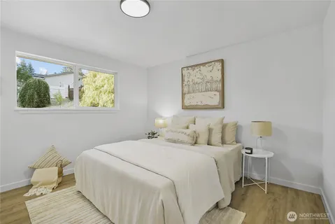 a bedroom with a bed and painting on the wall