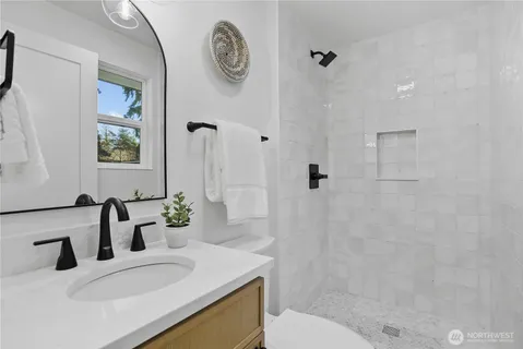 a bathroom with a granite countertop sink a toilet and shower