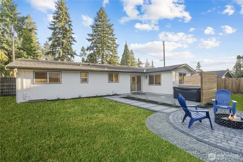 a view of a house with backyard and a tree
