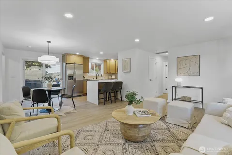 a living room with fireplace furniture and a view of kitchen