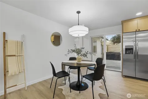 a kitchen with stainless steel appliances granite countertop a dining table chairs and a refrigerator