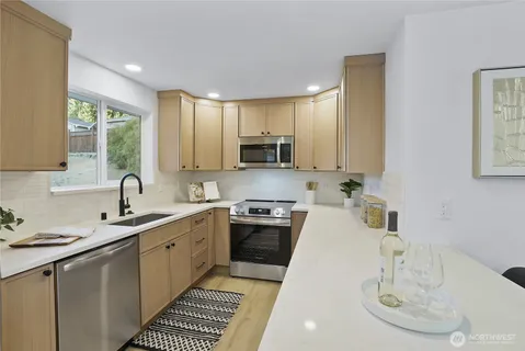 a kitchen with sink a microwave and cabinets