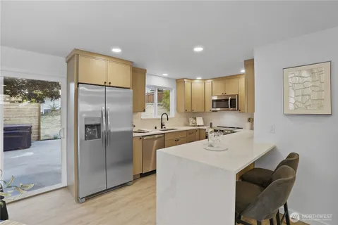 a kitchen with stainless steel appliances a refrigerator sink and microwave