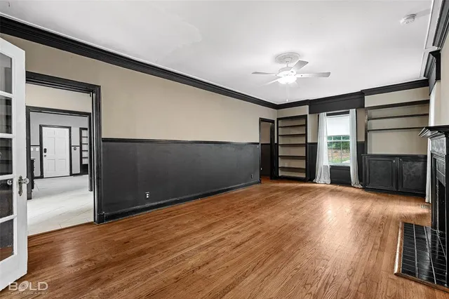 a view of empty room with wooden floor and ceiling fan