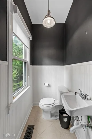 a bathroom with a sink a toilet and a window