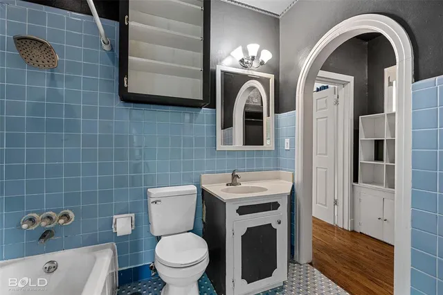 a bathroom with a toilet a sink and mirror