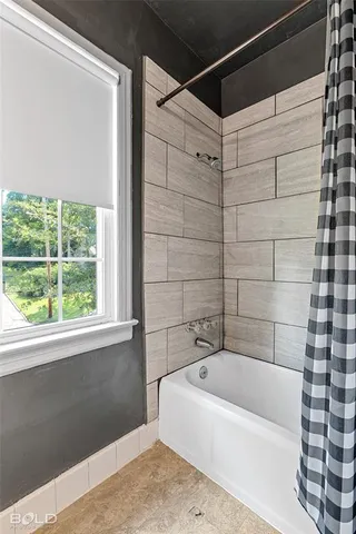 a bathroom with a bathtub and shower