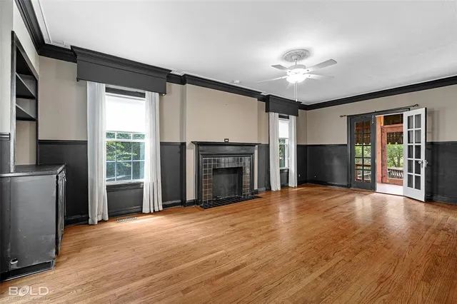 a view of an empty room with a fireplace and a window