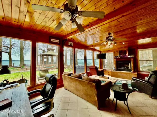 a living room with furniture a floor to ceiling window and a flat screen tv