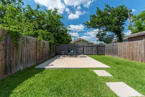 a view of a backyard with table and chairs and wooden fence