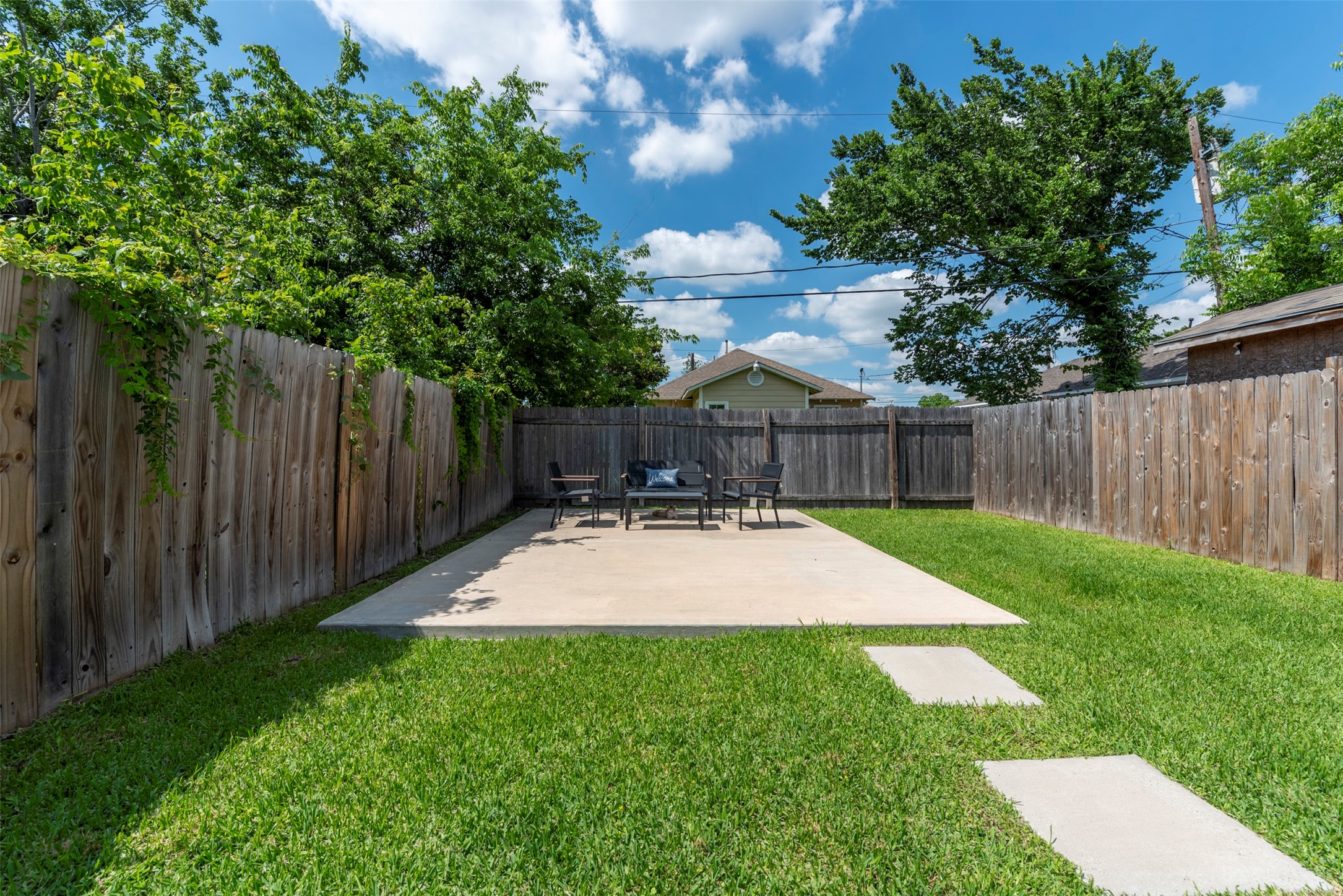 1121 Panama Street Houston, TX 77009 - Photo 30 of 35 Spacious fully fenced backyard with a large poured concrete patio, mature shade trees, manicured lawn, and privacy wood fence on all three sides.