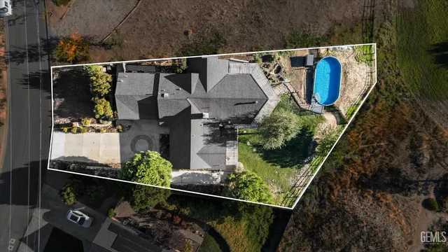 an aerial view of a house with a yard and large trees