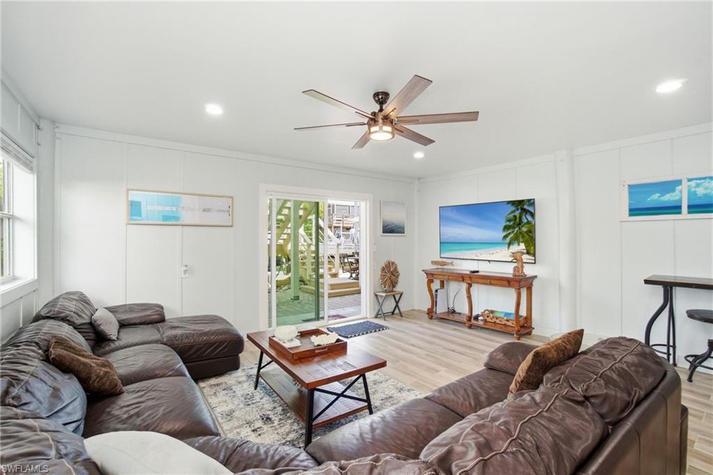 1286 Venetian Way Naples, FL 34110 - Photo 23 of 46 a living room with furniture a window and a flat screen tv