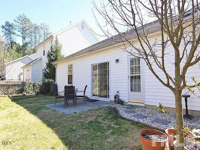 a view of a backyard with table and chairs and a patio