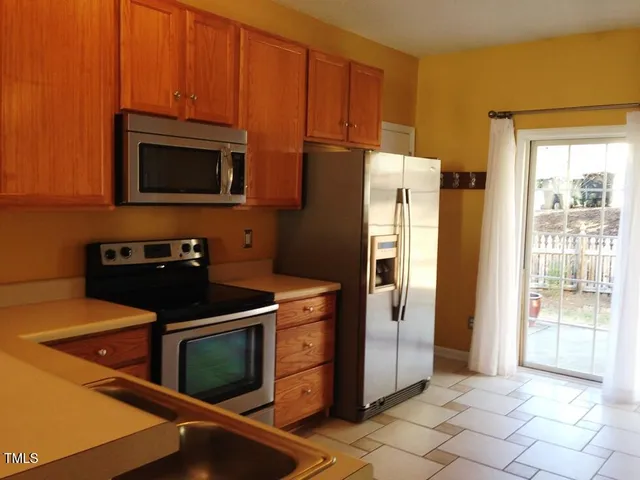 a kitchen with stainless steel appliances granite countertop a refrigerator stove and microwave