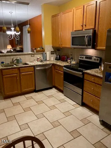 a kitchen with stainless steel appliances a stove a sink and a microwave