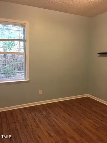 a view of a small space with wooden floor and a window