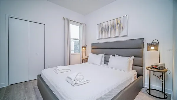 a bedroom with a bed and wooden floor