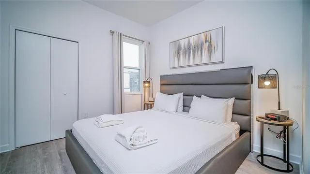 a bedroom with a bed and wooden floor