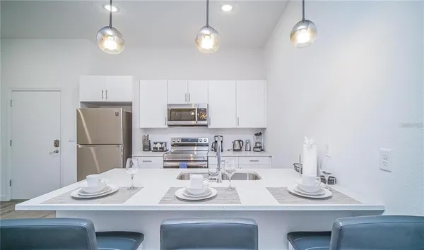 a kitchen with stainless steel appliances kitchen island granite countertop a sink and a stove