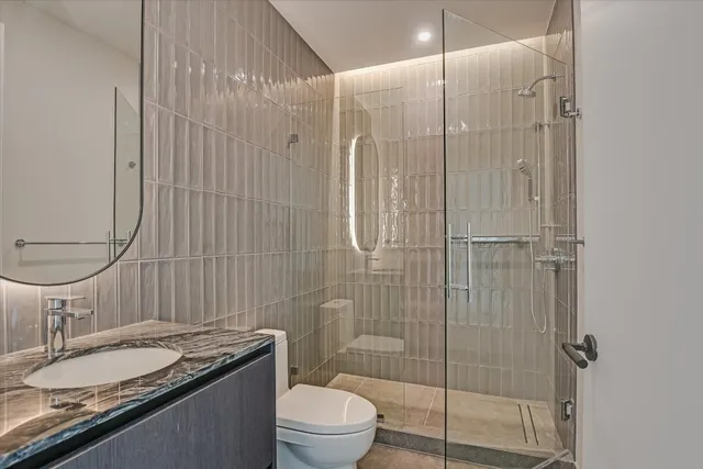 a bathroom with a granite countertop sink toilet and shower