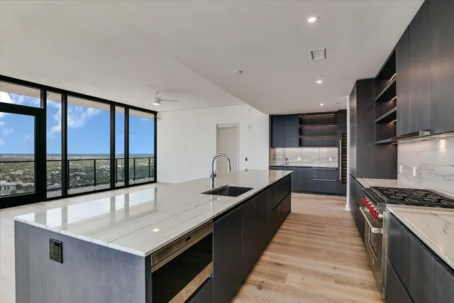 a kitchen with stainless steel appliances granite countertop a sink stove and refrigerator