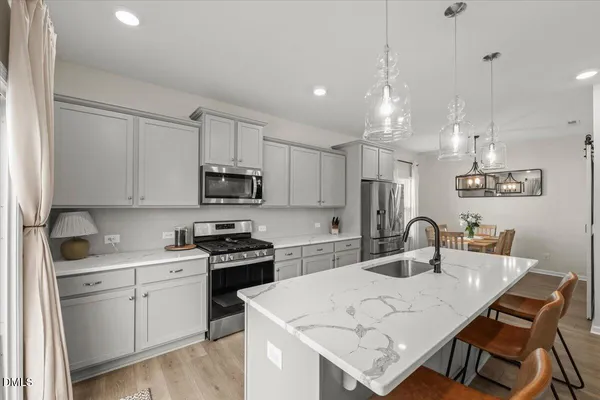 a kitchen with a white cabinets and chairs