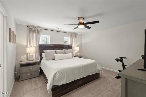 a bedroom with a bed and a ceiling fan