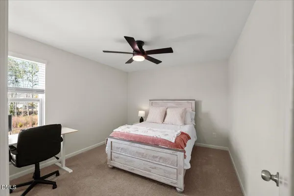 a bedroom with a bed a chair and a large window