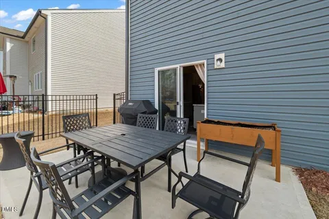a backyard of a house with wooden deck table and chairs